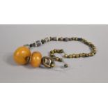 A Far Eastern Type Beaded Necklace Housing Two Large Amber Coloured Beads, Requires Restringing