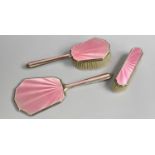 A Three Piece Silver and Pink Engine Turned Enamel Dressing Table Set to comprise Mirror, Hair Brush