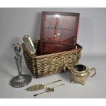 A Wicker Basket Containing Various Silver Plated Items to include Crumb Scoop, Candlestick Etc