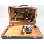 A Vintage Cased Electric Singer Sewing Machine with Power Cable and Foot Controller, untested