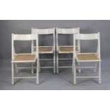 A Set of Four Modern Cane Seated White Painted Folding Chairs