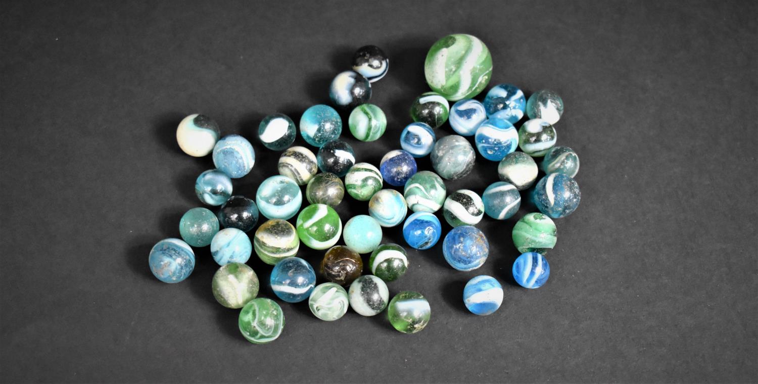 A Collection of Various Green, Blue and White Marbles