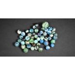 A Collection of Various Green, Blue and White Marbles