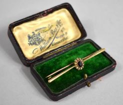 A Late Victorian/Edwardian Gold Bar Brooch with Central Facet Cut Red Stone Surround by Seed