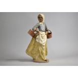 A Large Nao Figure, Girl with Two Wicker Baskets, 38cm high