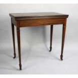 An Edwardian Mahogany Lift and Twist Top Games Table on Square Tapering Supports with Spade Feet and