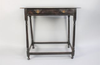 An Early 18th Century Country Made Oak Side Table with a Solid Plank Top Over a Frieze Drawer,