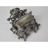 A Cast Metal Wall Mounting Match Holder with Scrolled and Pierced Back with Gnomes, 10x13cms High