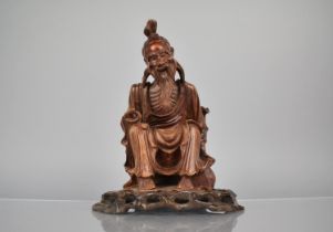 A 19th Century Carved Hardwood Figure of an Emaciated Holy Man Wearing a Wide Brimmed Hat and