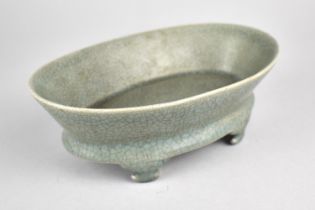 A Reproduction Celadon Oval Dish Raised on Four Scrolled Feet, 19cm wide