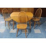 A 1970's Drop Leaf Dining Table Together with Three Hooped Back Chairs in the Windsor Style