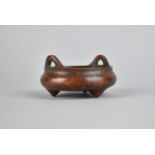 A Small Reproduction Chinese Bronze Censer of Squat Form with Lug Handles, Raised on Tripod