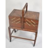 An Edwardian Oak Cantilevered Sewing Box on Trolley Stand, 49cms Wide