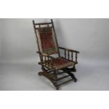 A Late Victorian Mahogany Spindle Framed American Rocking Chair with Tapestry Seat and Back, in Need
