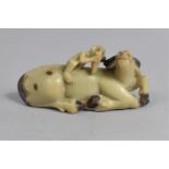 A Late 19th Century Chinese Carved Soapstone Model of a Buffalo, Modelled Recumbent with a Monkey on