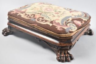 A Victorian Carved Wooden Footstool with Four Claw Feet and Tapestry Upholstery, 36x29cms