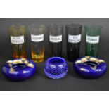 A Collection of Collection of Coloured Glass Beakers Inscribed with Chemist Labels for Vitriol,