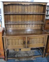 An Oak Sideboard with Panelled Cupboard Base Raised on Turned Supports and Having Two Tier Rack,