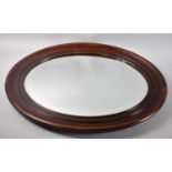 A Mahogany Framed Oval Wall Mirror with Bevel Cut Glass, 65x54cms