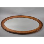 An Edwardian Oak Framed Oval Wall Mirror, 79x51cms