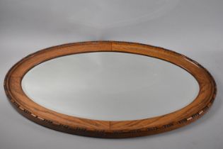 An Edwardian Oak Framed Oval Wall Mirror, 79x51cms