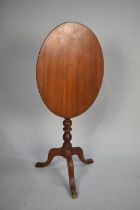 An Edwardian Mahogany Oval Snap Top Tripod Table with Bobbin Supports, 57cms High