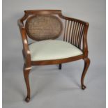An Edwardian Mahogany Framed Cane Backed Tub Armchair with Upholstered Seats, Cabriole Supports
