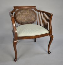 An Edwardian Mahogany Framed Cane Backed Tub Armchair with Upholstered Seats, Cabriole Supports