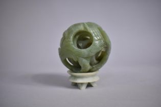 A Chinese Carved Green Hardstone Puzzle Ball on Stand, 11cms High