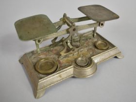 A Vintage Metal Postage Scale with Three Weights, 18cms Wide