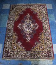 A Mid 20th Century Patterned Rug on Red Ground, 220x150cms