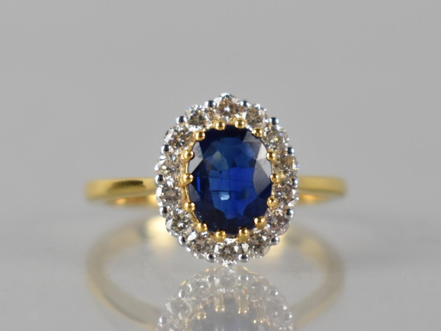 An 18ct Gold, Kyanite and Diamond Cluster Ring, Central Raised Claw Set Oval Cut Stone Measuring 1.
