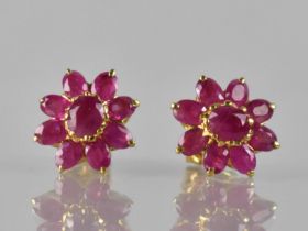 A Pair of Ruby and Gold Coloured Metal Cluster Earrings, Central Claw Set Oval Cut Ruby Measuring