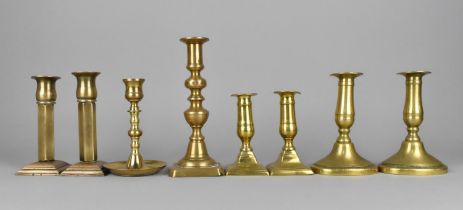 A Collection of Three Pairs and Two Single Brass Candlesticks