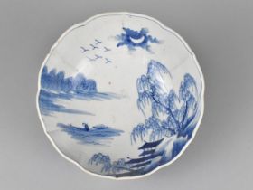 A Qing Period Chinese Blue and White Bowl of Lobed Form Decorated with River Village Scene, Having