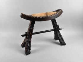 A Carved Wooden Oval Topped Stool with Animal Skin Pad Seat, 46cms Wide