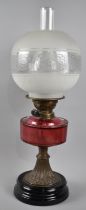 A Late Victorian Oil Lamp with Cranberry Glass Reservoir, 56cms High Overall