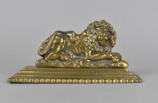 A 19th Century Brass Doorstop/Fireside Ornament in the Form of a Reclining Lion on Stepped