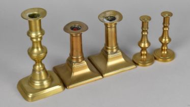 A Collection of Two Pairs and One Single Brass Candlesticks, Latter 16cms High