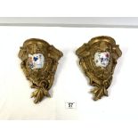 A PAIR OF ORNATE GILTWOOD WALL BRACKETS WITH INSET CHINESE PORCELAIN DECORATION. 23CMS.