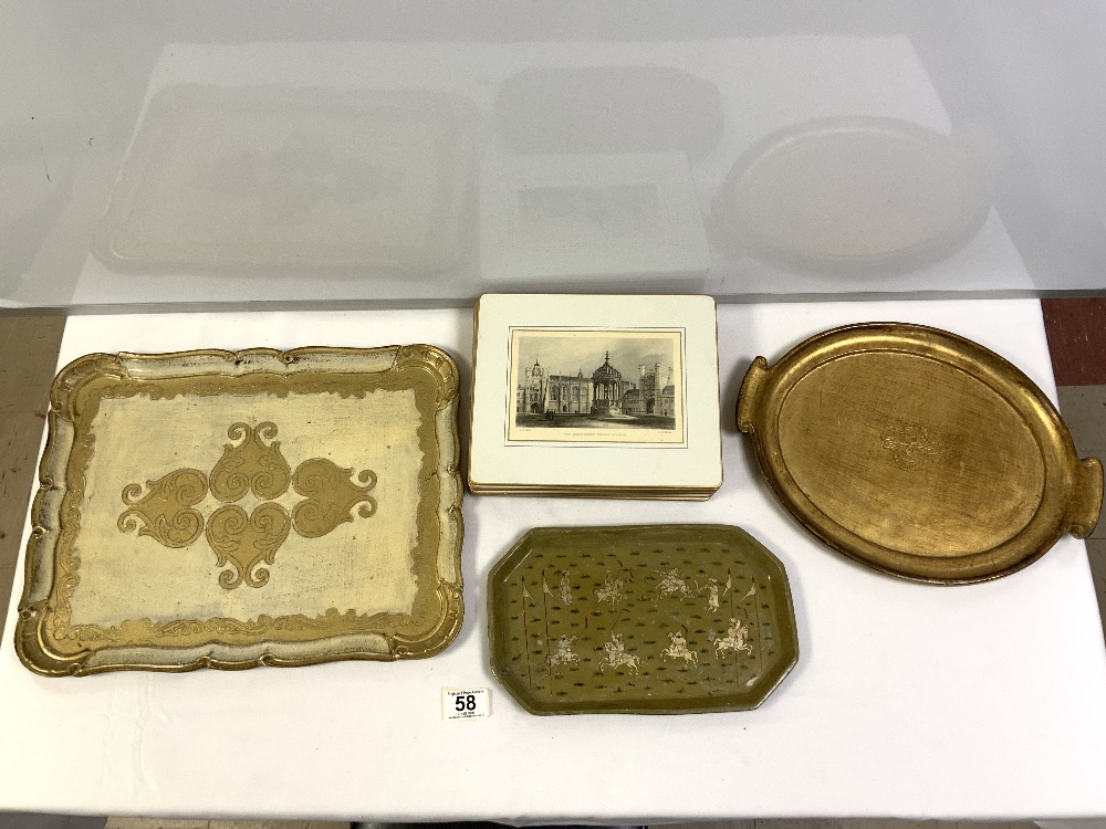 TWO GILT DECORATED TEA TRAYS, A SMALL LAQUERED INDIAN TRAY AND SET OF EIGHT SCENIC PLACE MATS.