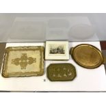 TWO GILT DECORATED TEA TRAYS, A SMALL LAQUERED INDIAN TRAY AND SET OF EIGHT SCENIC PLACE MATS.