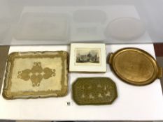 TWO GILT DECORATED TEA TRAYS, A SMALL LAQUERED INDIAN TRAY AND SET OF EIGHT SCENIC PLACE MATS.