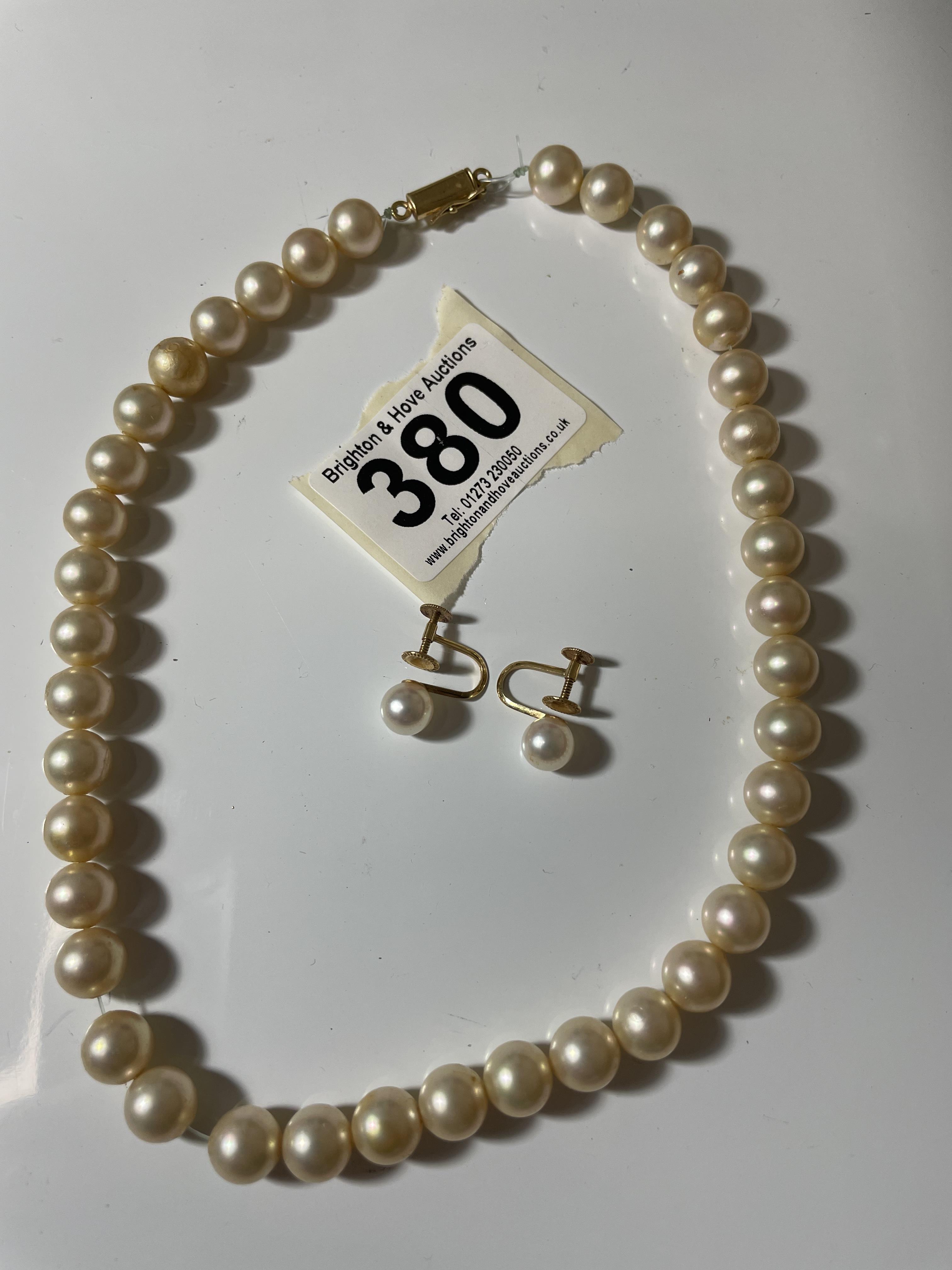 A PEARL NECKLACE WITH YELLOW METAL 18K CLASP AND PAIR OF PEARL AND 18K EARINGS.