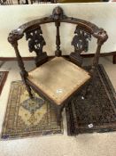 A NINETEENTH CENTURY ITALIAN CARVED WALNUT CORNER CHAIR, WITH LIONS HEAD HAND RESTS.