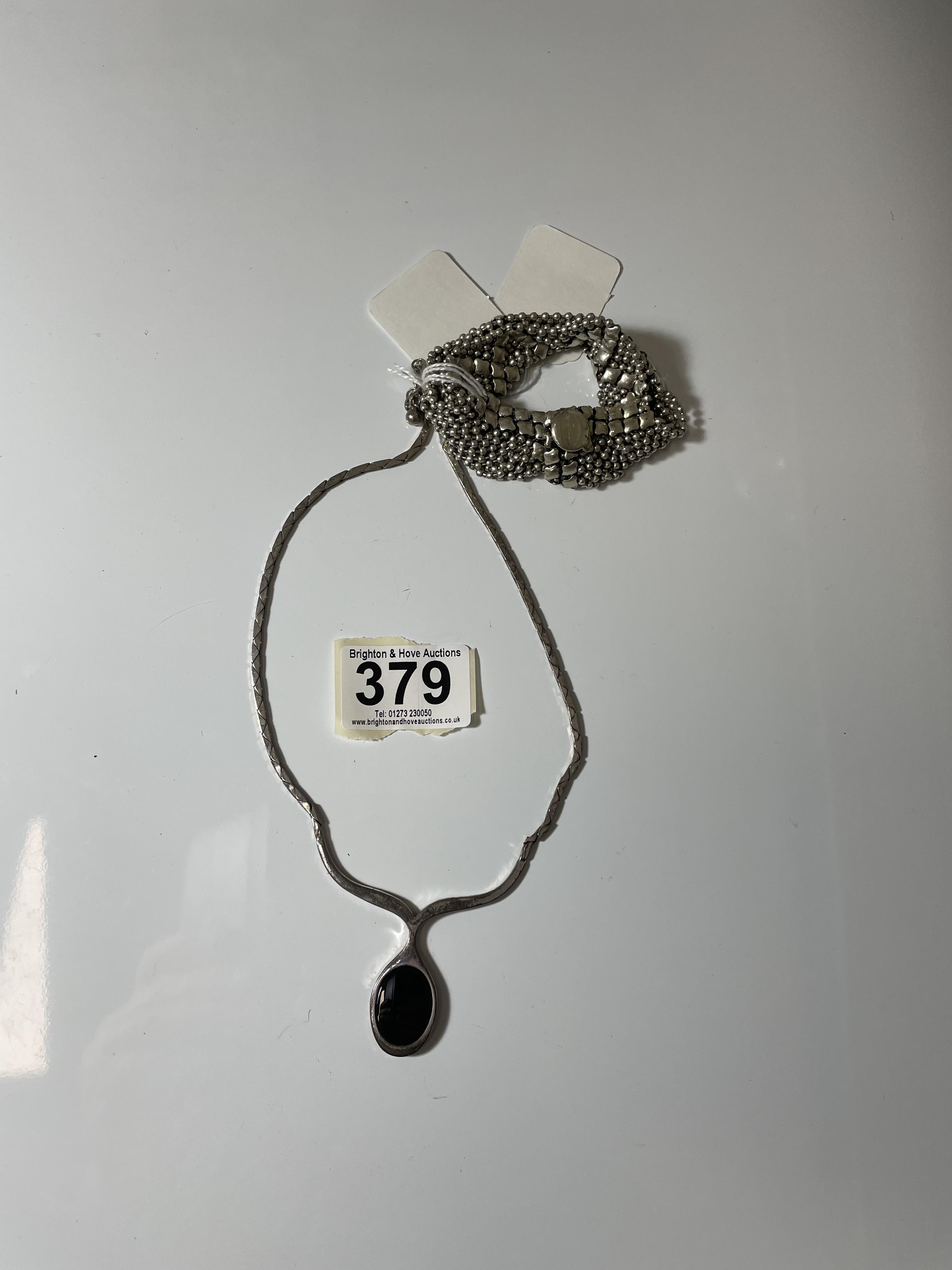 A WHITE METAL NECKLACE COMBINED BLACK ONYX PENDANT, STAMPED 835, AND A WHITE METAL BRACELET