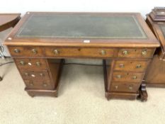 A VICTORIAN MAHOGANY ROUND CORNER PEDESTAL DESK WITH NINE DRAWERS, AND A TOOLED GREEN LEATHER TOP.