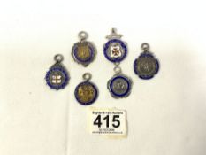 FOUR HALLMARKED SILVER AND ENAMEL CRICKET PENDANTS, AND ONE FOOTBALL AND ONE OTHER. 69 GRAMS.