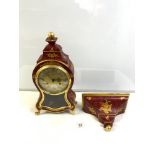 A 20-CENTURY RED AND GOLD LACQUER-SHAPED BRACKET CLOCK BY -LE CASTEL. WITH A SWISS MOVEMENT, 110177.