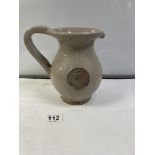 A GLYNDEBOURNE GLAZED POTTERY PITCHER JUG WITH APPLIED COAT OF ARMS. 20 CMS.